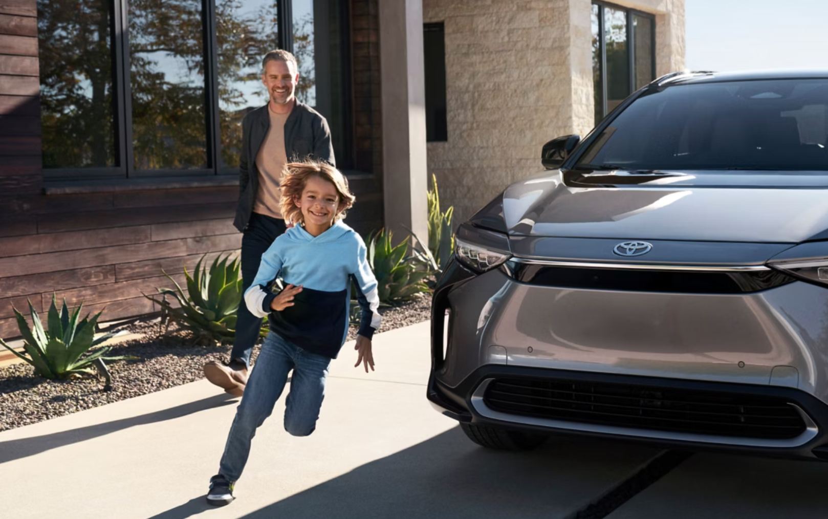 People eagerly approaching a new Toyota vehicle parked outside a house