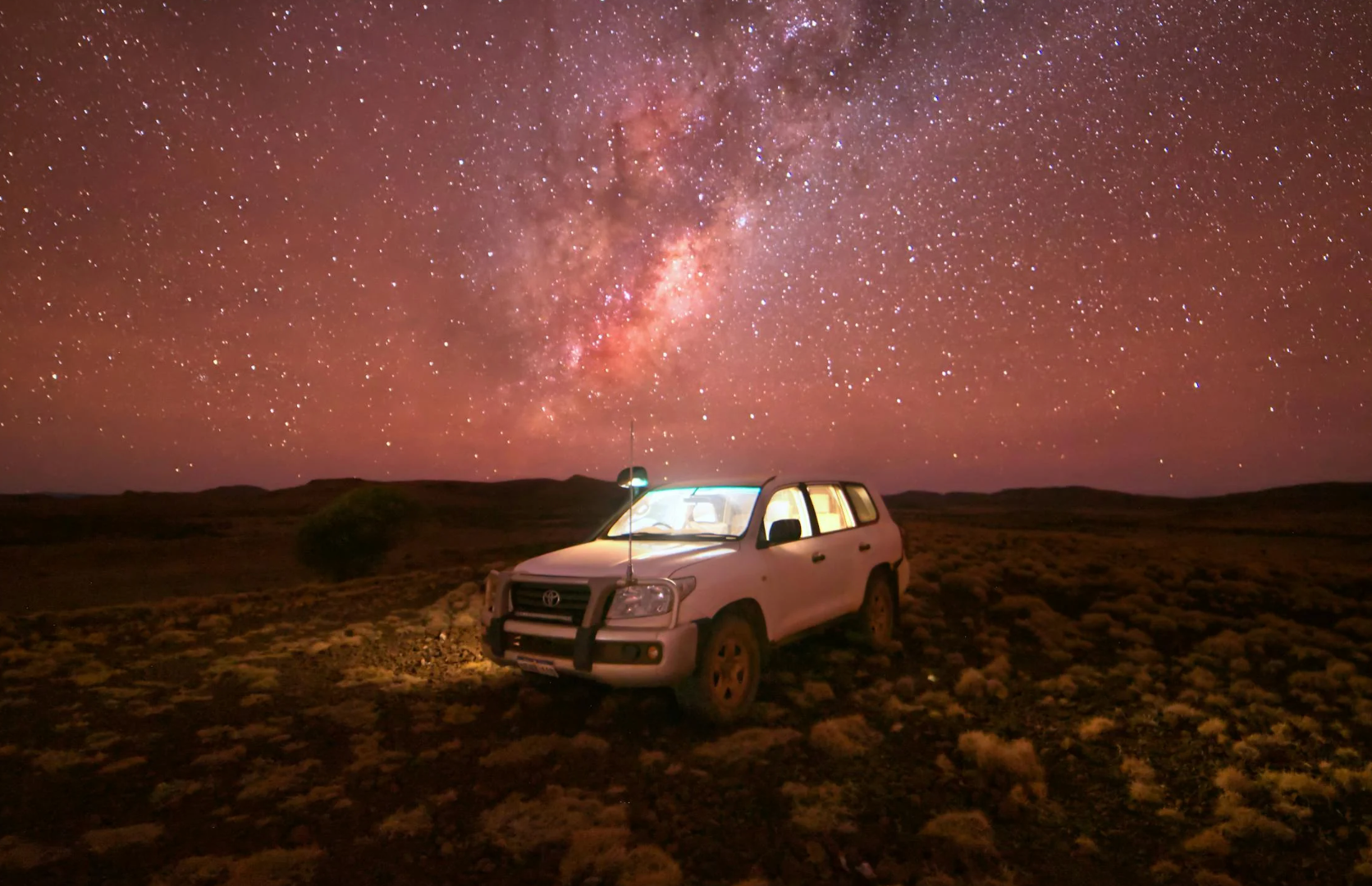 White Toyota SUV on Brown Field Under Starry Night